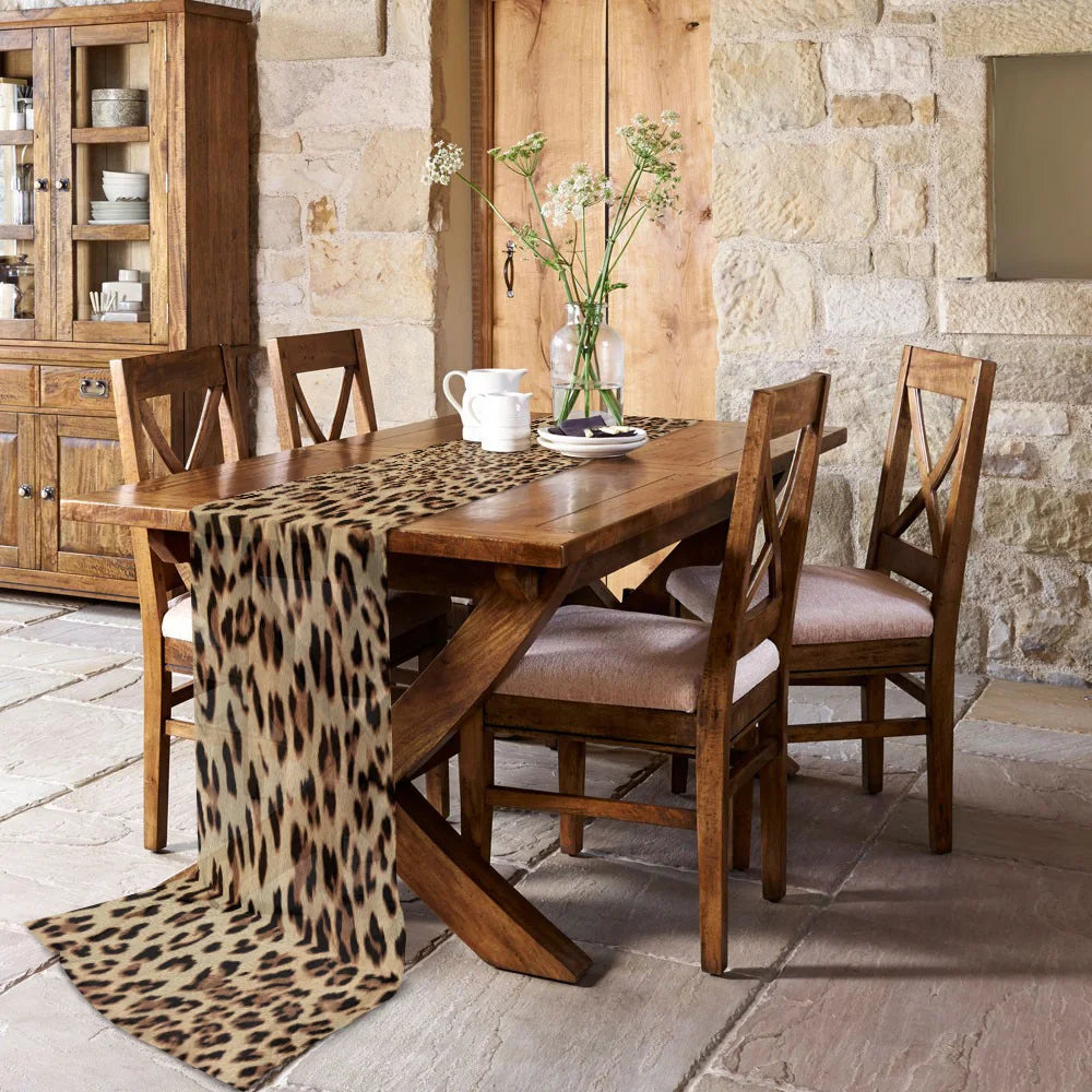 chemin de table leopard sur une table et maison style ancien en pierre